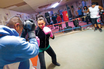 Alicia Draper spars with Walter Francis while others wait their turn during boxing practice at the Damon Bahe Boxing Gym in Chinle Tuesday.  © 2011 Gallup Independent / Cable Hoover 
